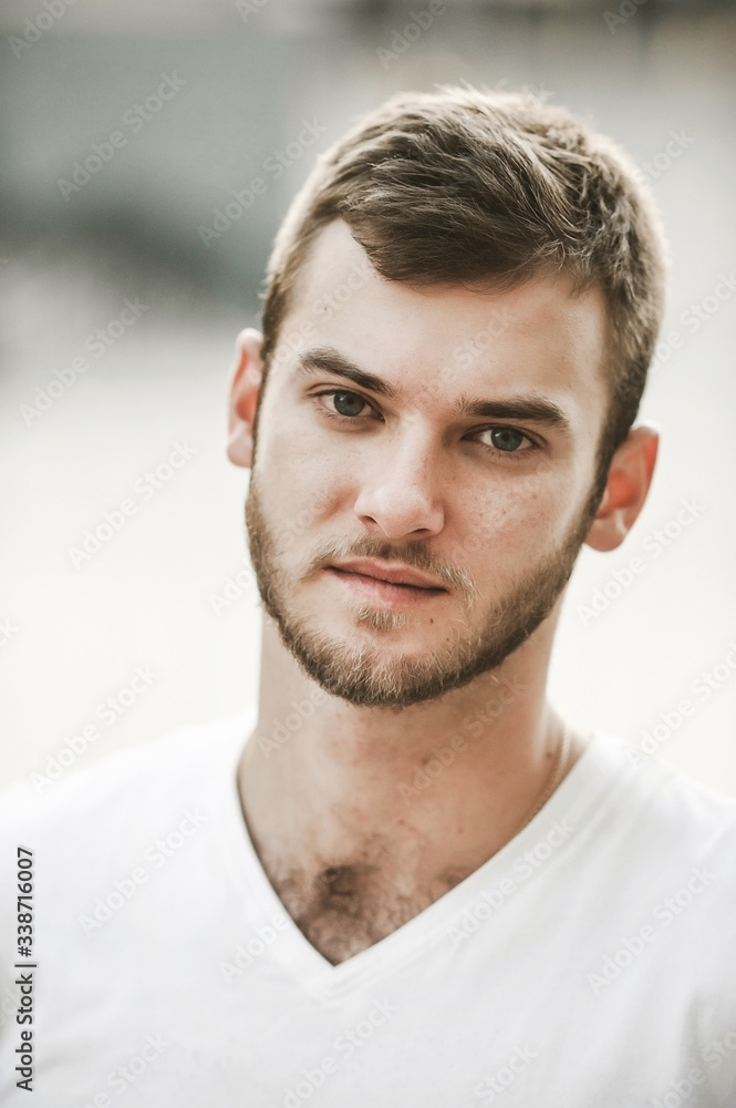 Obraz premium smiling friendly guy with a variety of emotions; a man in a white T-shirt and jeans with a clock on his hand;