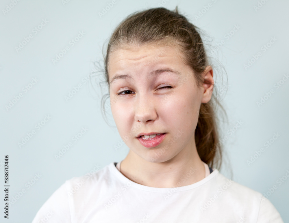 Wink, young girl covers her eye, portrait on background, emotions series. Wink, young girl covers her eye, portrait on background, emotions series.