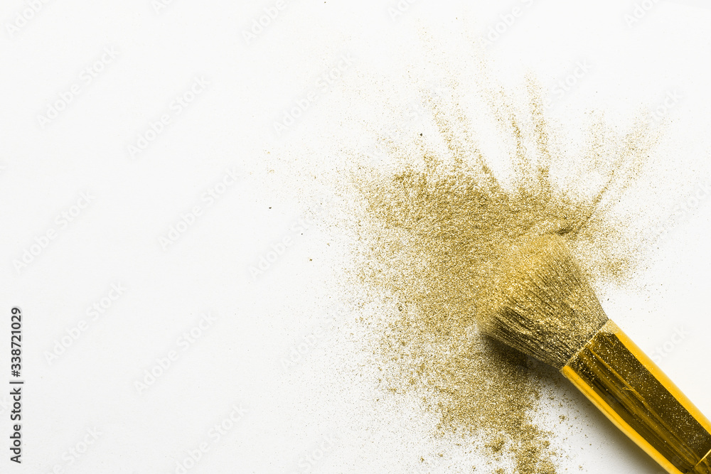 golden fine powder splash and brush for makeup artist or graphic design in white background. golden fine powder splash and brush for makeup artist or graphic design in white background.