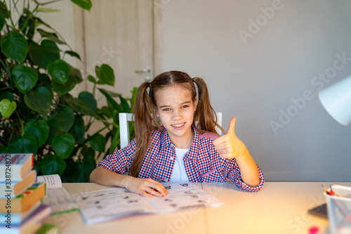 teenager girl in a plaid shirt doing homework