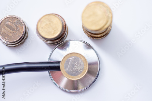 Stethoscope on coin stack, Dollar, and red heart on white background. money for health care, Financial Aid, concept.
