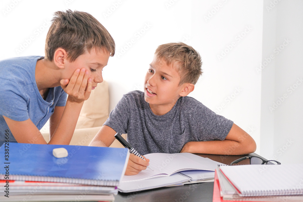 Learning at home, self quarantine concept. Children at home doing together homework with books notebooks and talking Learning at home, self quarantine concept. Children at home doing together homework with books notebooks and talking