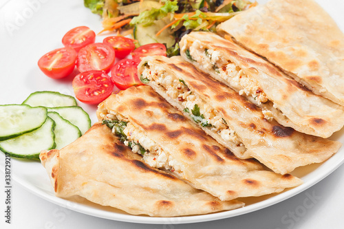 Turkish gozleme tortilla. Tortilla with vegetables on a white plate.