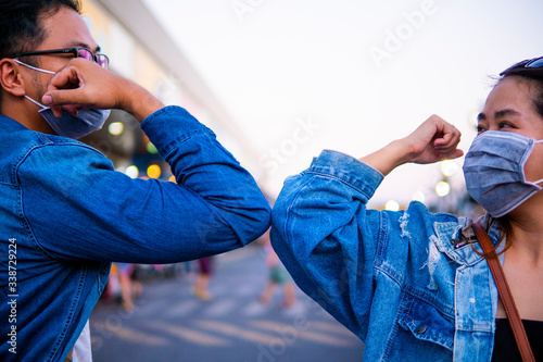 A new way of greeting to avoid the spread of coronavirus (COVID-19). Two people (a man and a woman) bump elbows instead of hug or handshake.