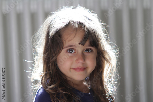 4 and a half year old girl looking and smiling at the camera