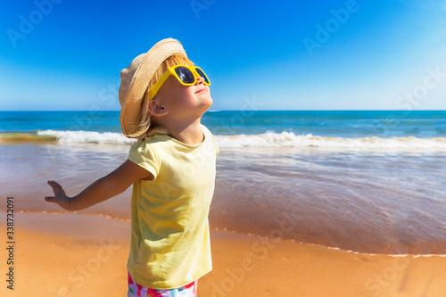 Happy child enjoying to the sun at the beach