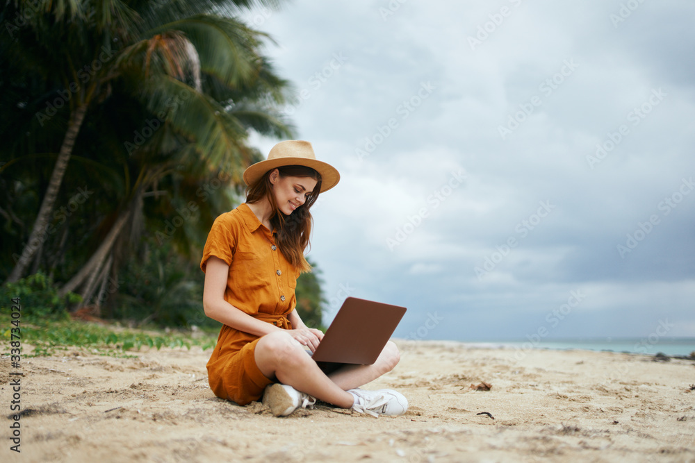 woman with laptop on the beach