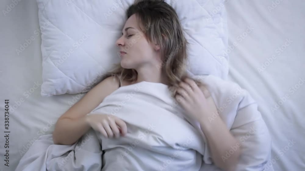 Top view of beautiful young woman sleeping on bed in morning. Concept of sleep and rest Top view of beautiful young woman sleeping on bed in morning. Concept of sleep and rest