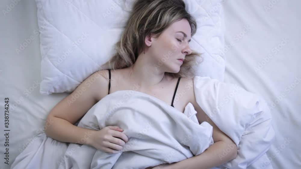 Top view of beautiful young woman sleeping on bed in morning. Concept of sleep and rest Top view of beautiful young woman sleeping on bed in morning. Concept of sleep and rest