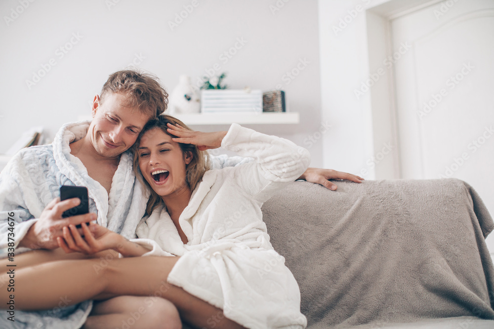 Fototapeta premium young couple watching phone. Couple in love. Love concept. Holidays. Home. 