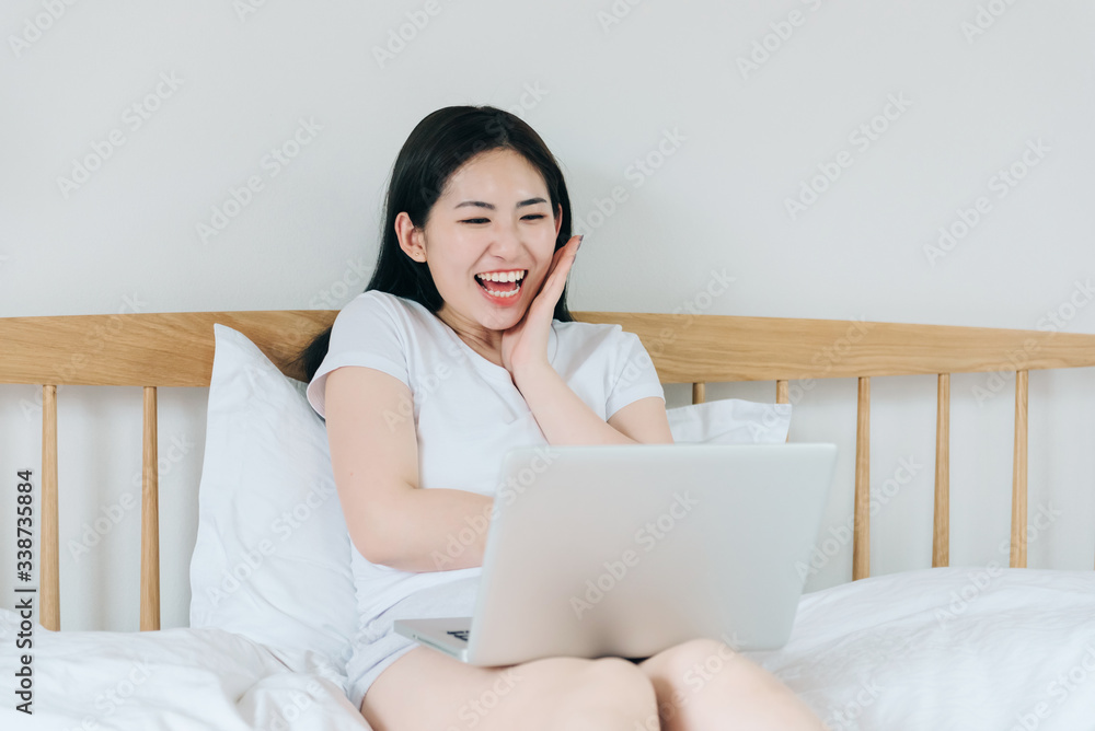 Young Asian girl using laptop in bed Young Asian girl using laptop in bed