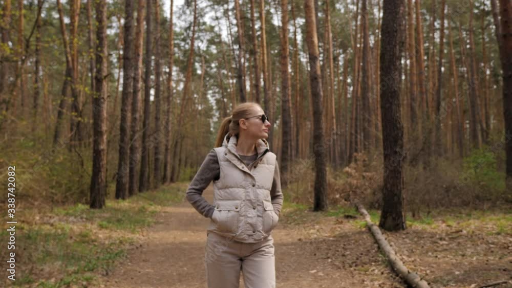 Beautiful woman in jacket waistcoat walk alone trailpath in pine forest in 4K Beautiful woman in jacket waistcoat walk alone trailpath in pine forest in 4K