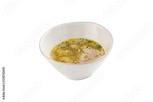 chicken broth with meatballs and herbs in bowl isolated on white background