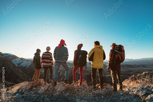 Group of hikers on mountain top at sunset