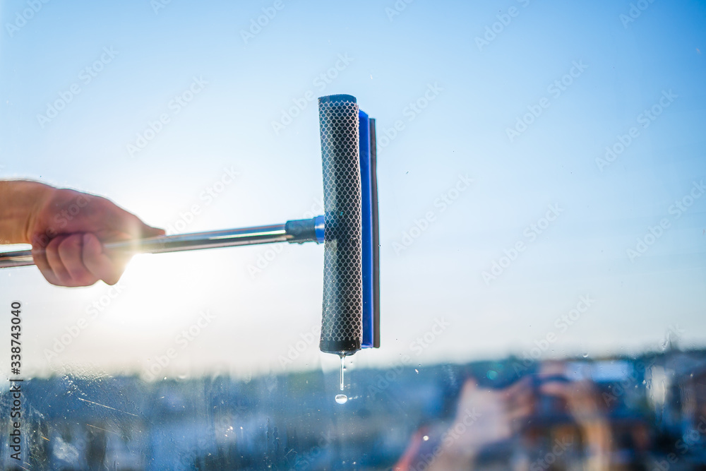 Window cleaning in high-rise buildings, houses with a brush. Window cleaning brush. Large window in a multi-storey building, cleaning service. Dust removal and glass washing. Window cleaning in high-rise buildings, houses with a brush. Window cleaning brush. Large window in a multi-storey building, cleaning service. Dust removal and glass washing.