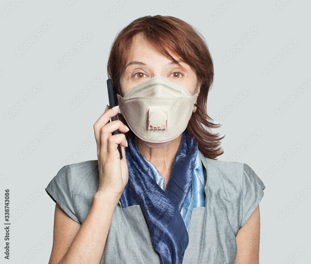 Beautiful older business woman executive in medical mask phone Beautiful older business woman executive in medical mask phone