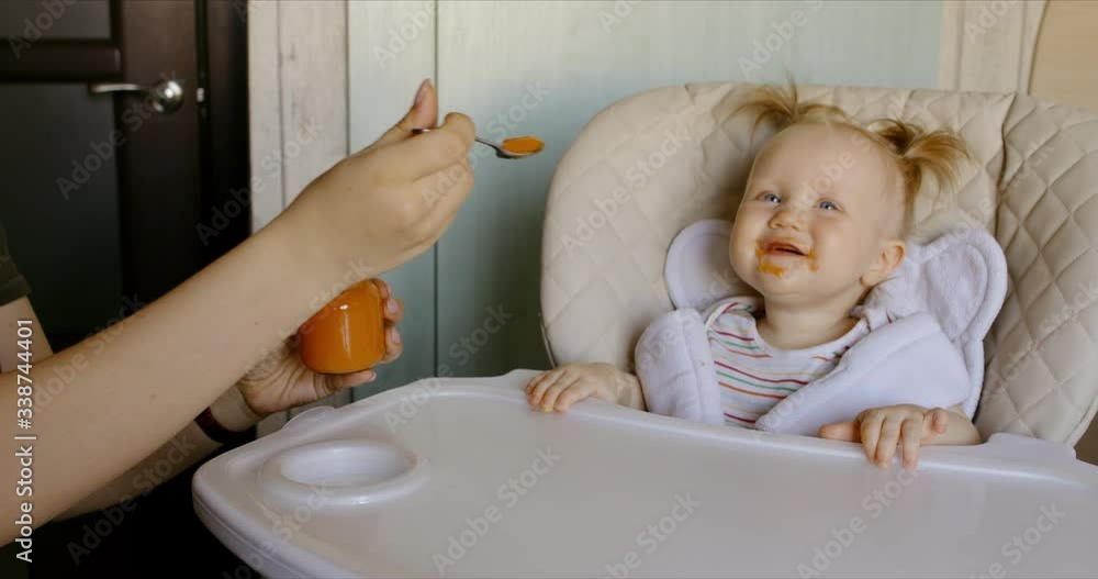 Caucasian mother feeding baby with spoon. RAW Graded footage 4K slow motion 60fps Caucasian mother feeding baby with spoon. RAW Graded footage 4K slow motion 60fps