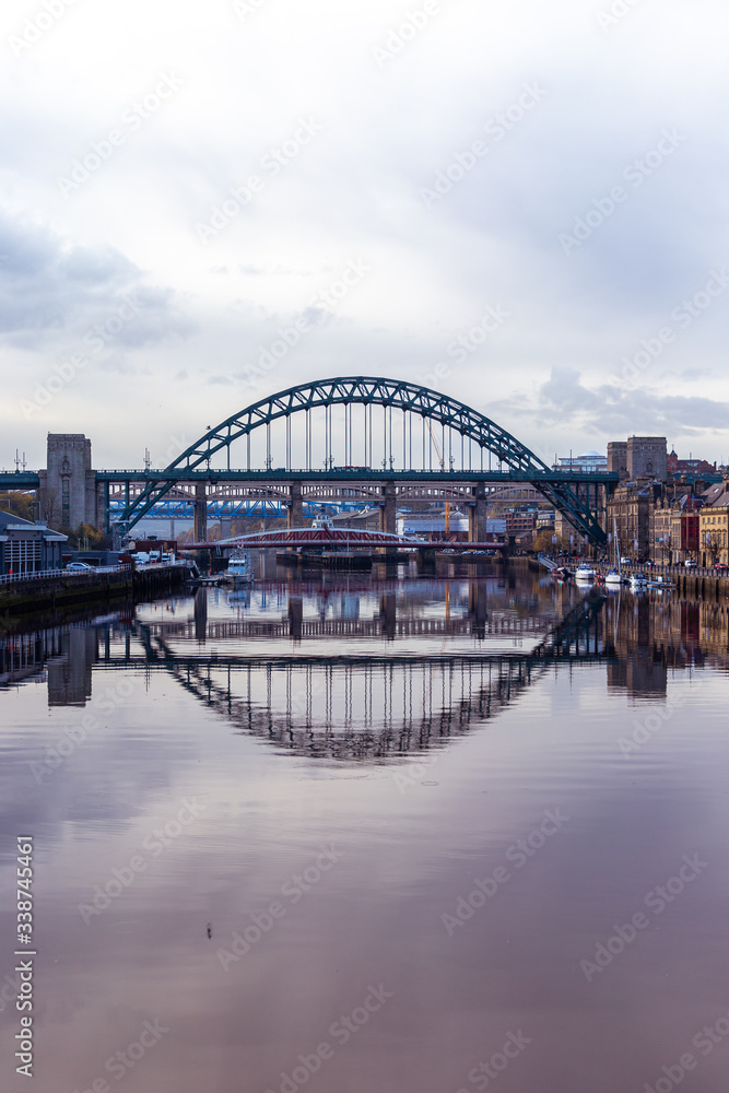 Fototapeta premium Tyne Bridge mirrored in the River Tyne, Newcastle, UK with Swing bridge, Queen Elizabeth II bridge and High Level bridge in the background