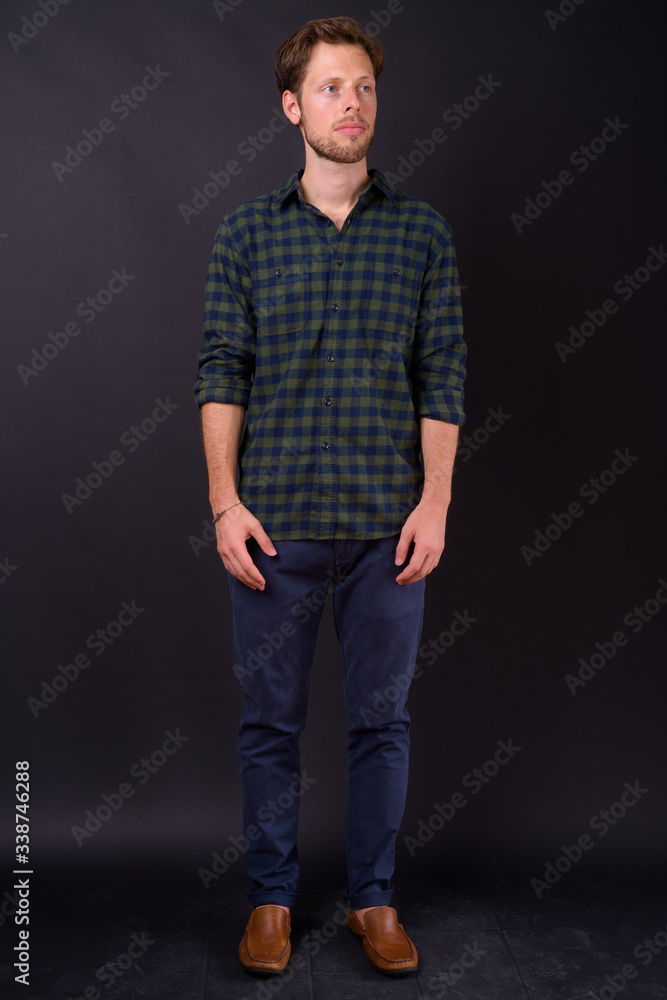 Full body shot of bearded hipster man thinking