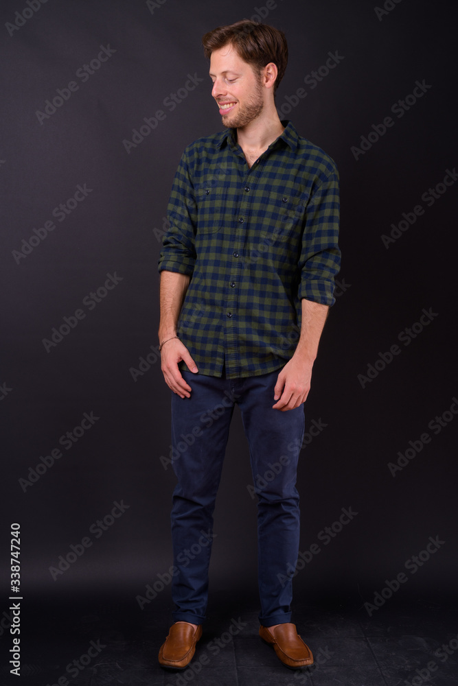 Full body shot of happy bearded hipster man looking down Full body shot of happy bearded hipster man looking down