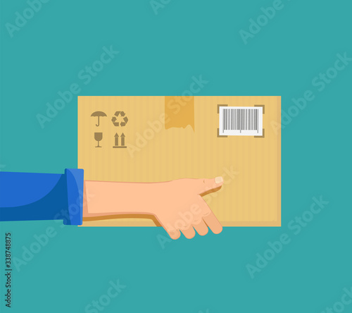 Delivery man or postman holds a cardboard box parcel