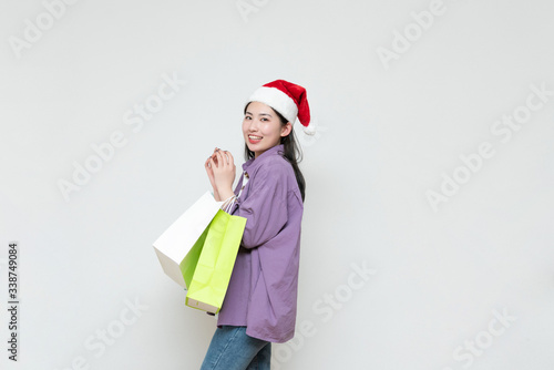 A young asian woman with a shopping bag in her hand