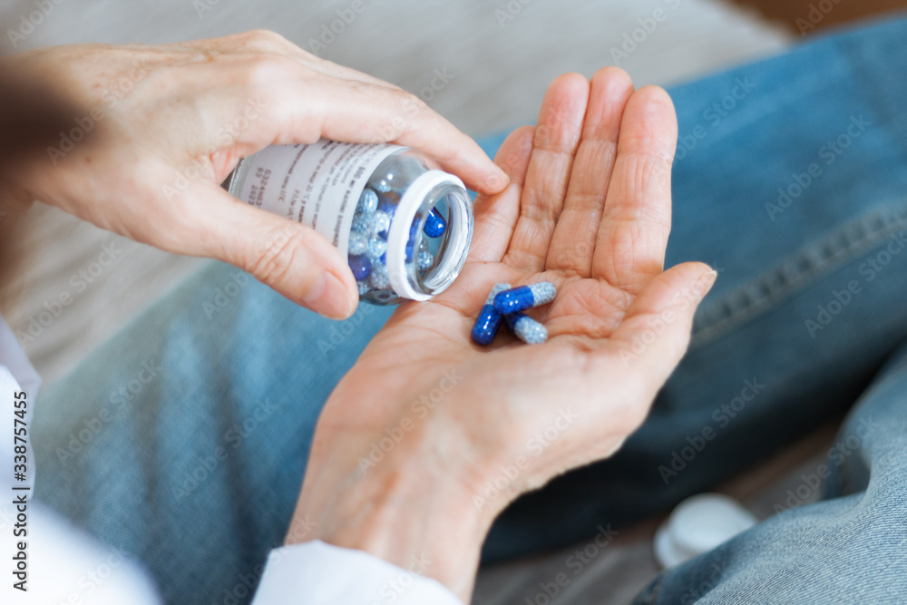 Female hand close up holding a medicine, elderly woman hands with pill on spilling pills out of bottle . Female hand close up holding a medicine, elderly woman hands with pill on spilling pills out of bottle .