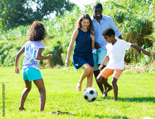 Parents with children playing football