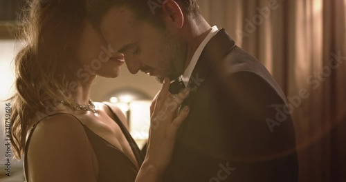 Elegant couple dancing sensually at a party. Loving young couple sharing a sensuous moment at a party.
