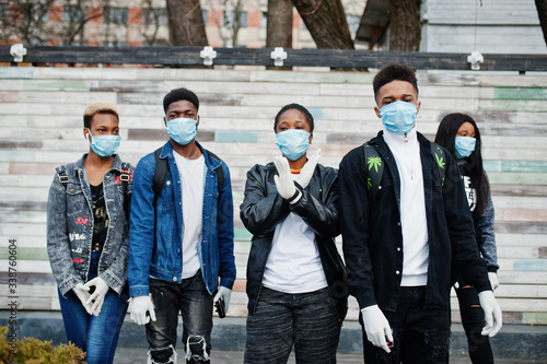 Group of african teenagers friends wearing medical masks protect from infections and diseases coronavirus virus quarantine.
