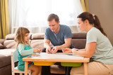  Family Dad, Mom and Little Daughter playing  board game together at home. quarantine. health concept. Corona Virus. Family having fun playing at home. stay home concept