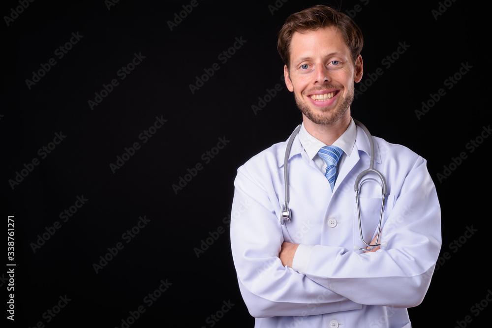 Portrait of happy bearded man doctor smiling with arms crossed Portrait of happy bearded man doctor smiling with arms crossed