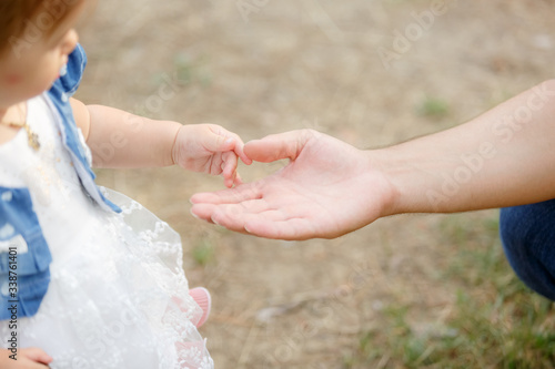the little kid’s hand touches the hand of an adult