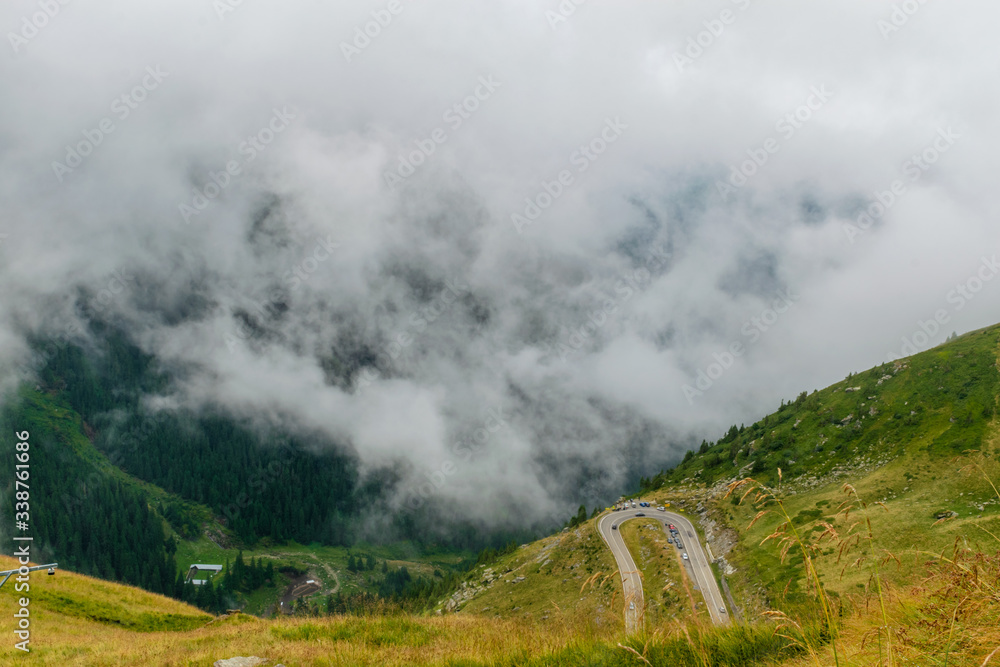 The road that crosses the Fagaras mountains seen from above among the fog, Transfagarasan, Romania