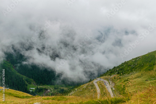 The road that crosses the Fagaras mountains seen from above among the fog, Transfagarasan, Romania