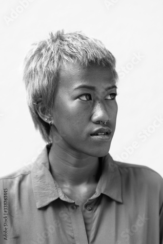 Face of young rebellious Asian woman with short hair thinking