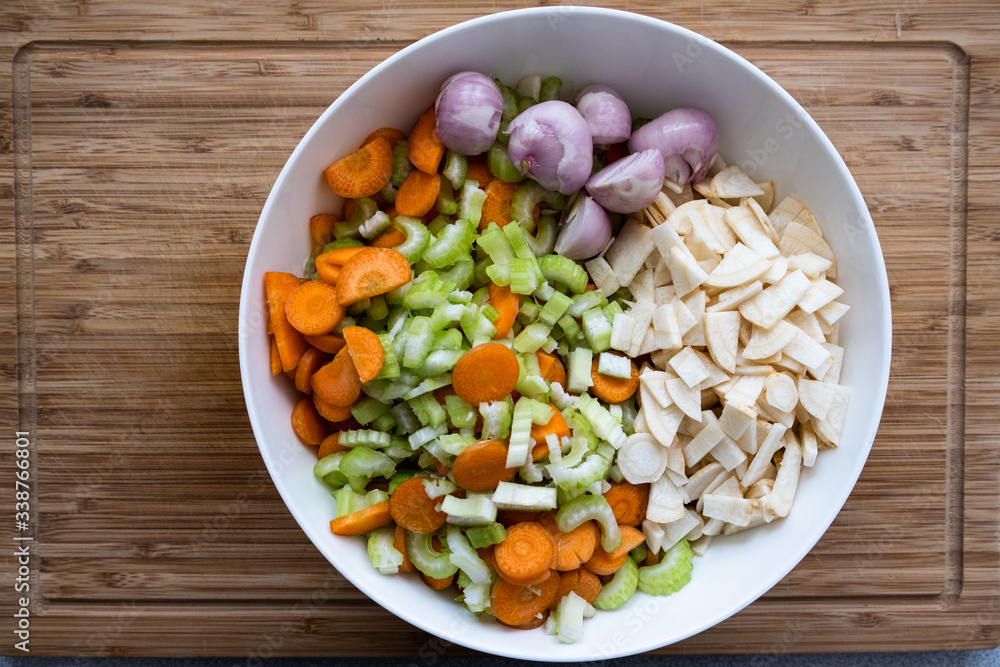 colorful fresh chopped vegetables in a white bowl on a wooden cutting board colorful fresh chopped vegetables in a white bowl on a wooden cutting board