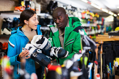 Multiracial couple choosing ski boots