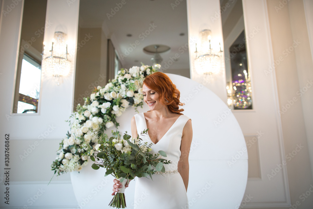 Beautiful girl posing in reception room with bouquet of flowers in hand Beautiful girl posing in reception room with bouquet of flowers in hand
