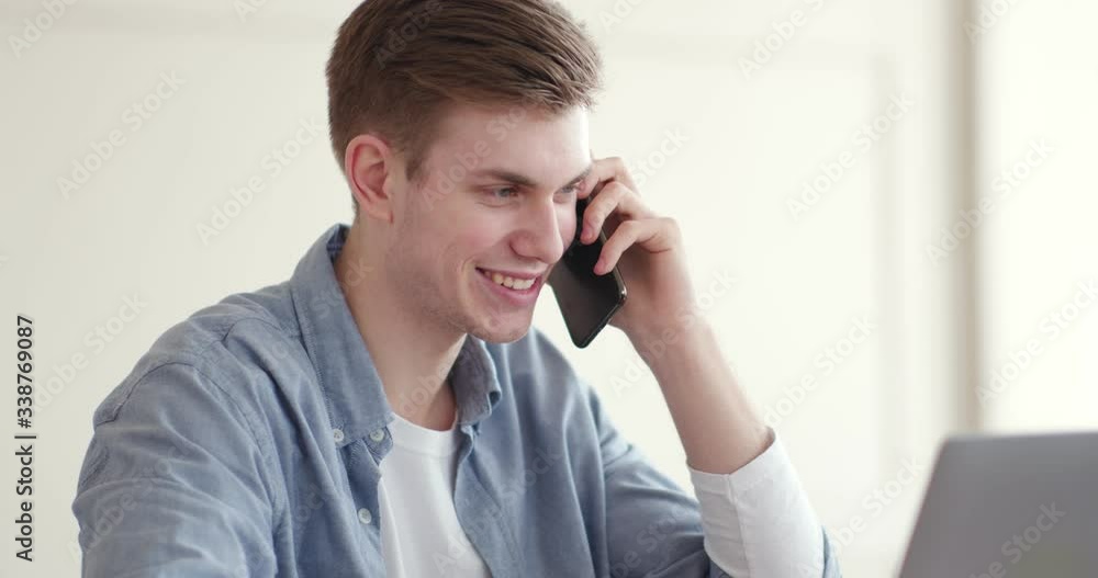 Friendly sales manager talking on phone, working at home office Friendly sales manager talking on phone, working at home office