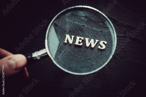 Focus on News.  News Word Magnifying Glass on black background