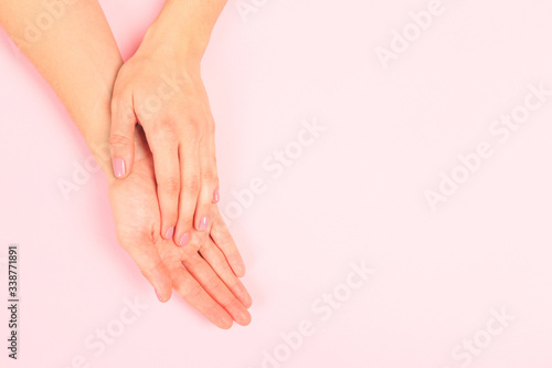 female  manicure. Beautiful young woman's hands on pastel pink  background - Image © Fototocam