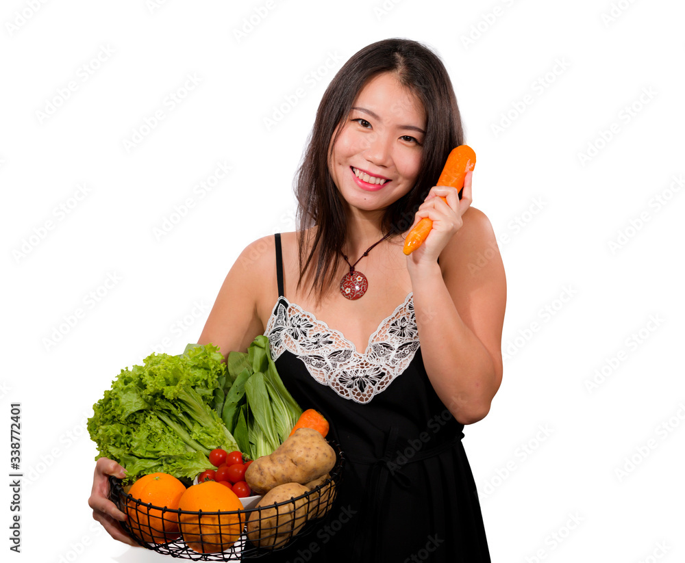 young happy and beautiful Asian Chinese woman holding basket full of vegetables smiling cheerful holding carrot playful in healthy organic and natural nutrition young happy and beautiful Asian Chinese woman holding basket full of vegetables smiling cheerful holding carrot playful in healthy organic and natural nutrition