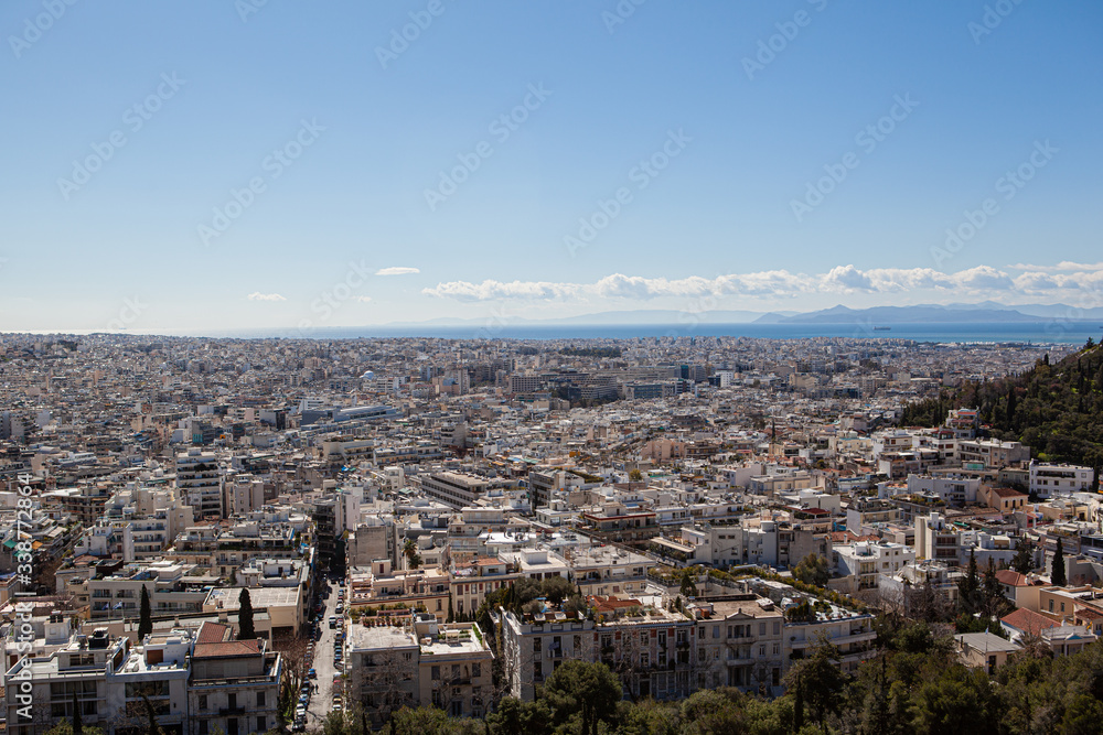 skyline of the city of Athens from the top of a hill with the sea in the background