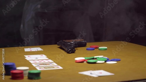 Handgun Rests on Abandoned Poker Table in Smokey Room photo