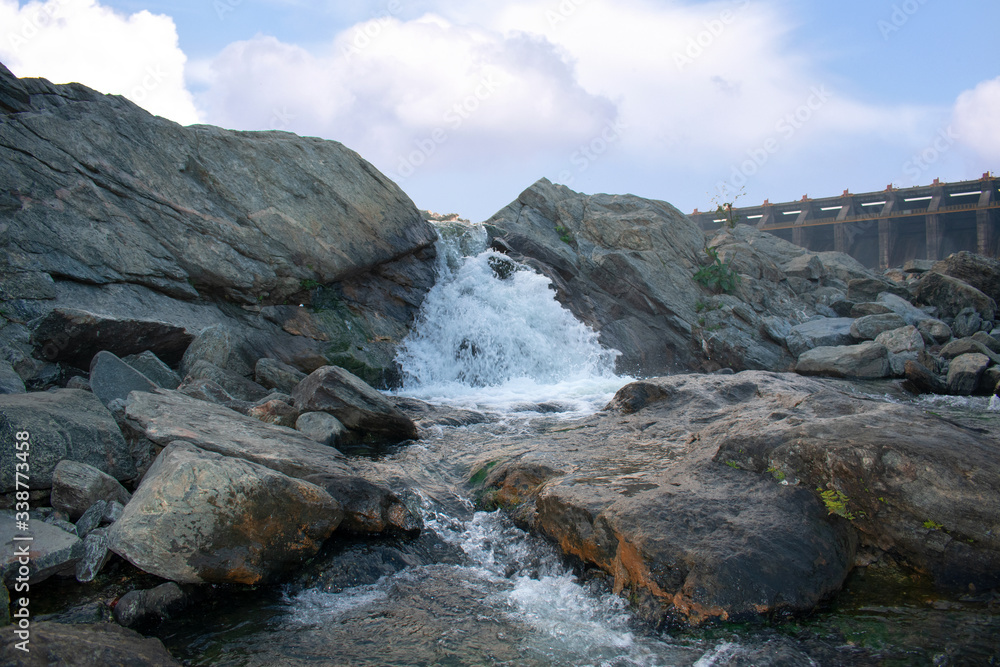 Obraz premium a small waterfall with beautiful clouds in the background