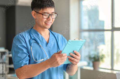 Male Asian doctor with clip...