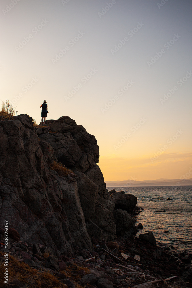 lonely person on cliff at sunset