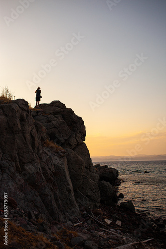 lonely person on cliff at sunset