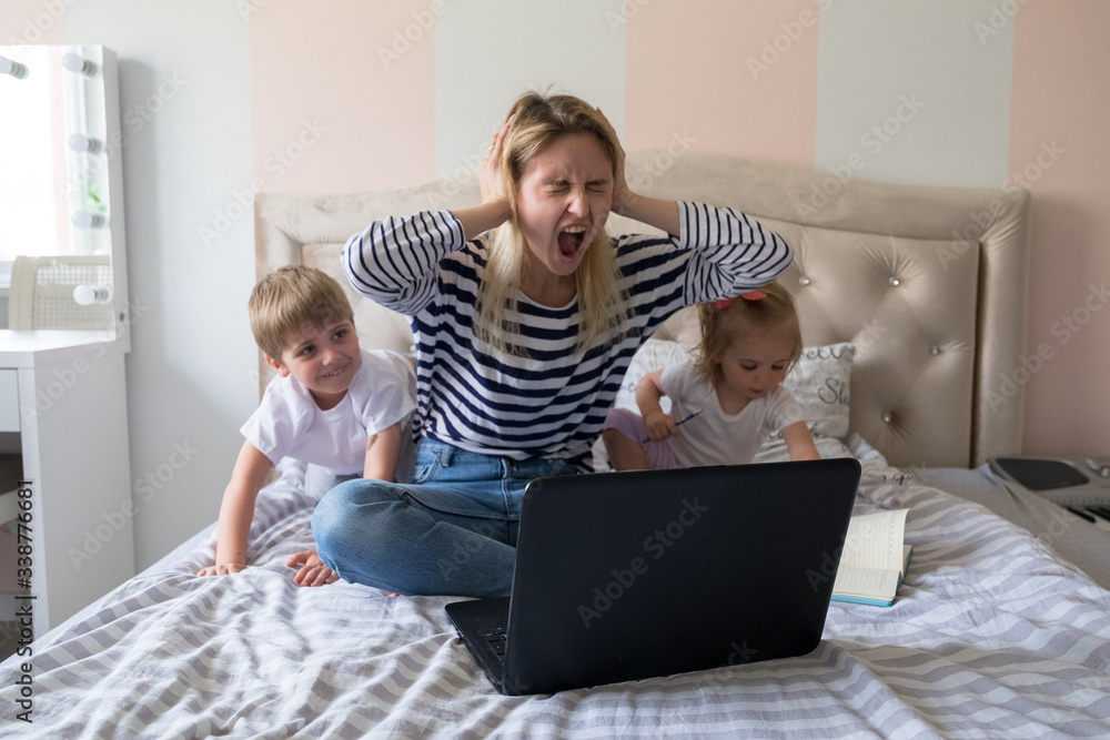 Mother working from home with kids. Quarantine and closed school during coronavirus outbreak. Children make noise and disturb woman at work. Homeschooling and freelance job. Boy and girl playing. Mother working from home with kids. Quarantine and closed school during coronavirus outbreak. Children make noise and disturb woman at work. Homeschooling and freelance job. Boy and girl playing.